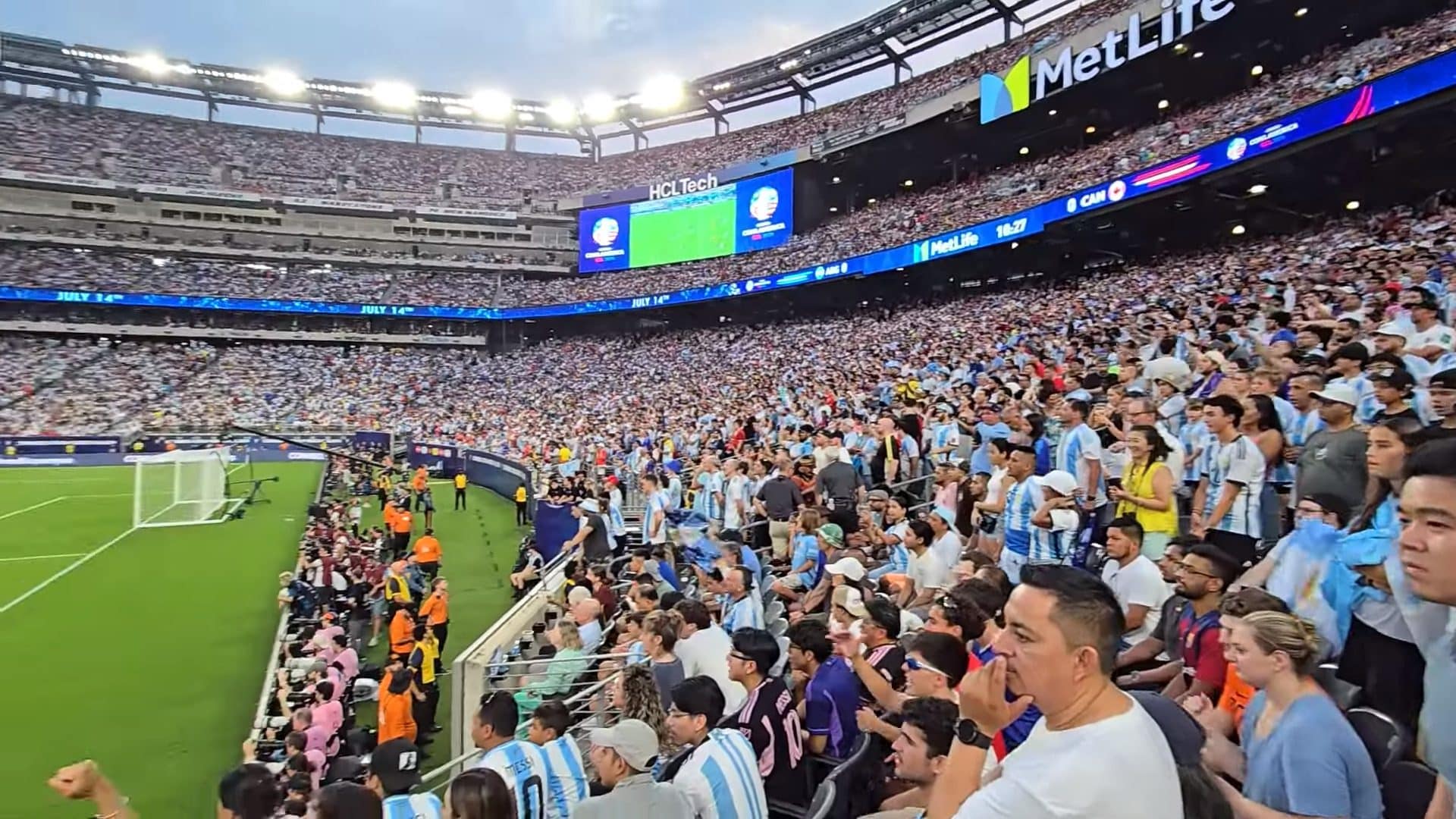 A packed stadium crowd under the floodlights